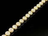 un bracelet tennis en or jaune serti de diamants sur fond noir