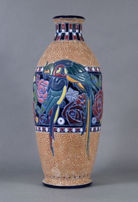 un grand vase orné d'un oiseau, posé sur une table