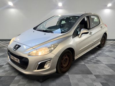 une voiture argentée est garée dans une pièce au sol en damier