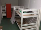 un lit superposé au milieu d'une pièce avec une porte rouge