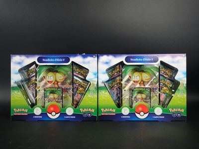 deux boîtes de cartes à collectionner Pokémon posées sur une surface noire