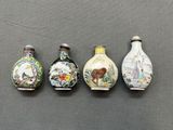 quatre petits vases aux motifs variés, posés sur une table
