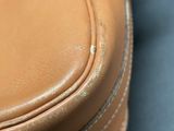 a close up of a tan leather bag on a table