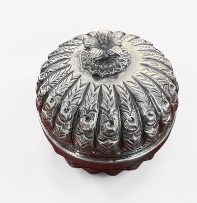 a silver box with a design on it on a white surface