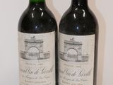 two bottles of wine sitting on top of a table next to each other