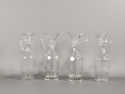 quatre vases en verre transparent posés les uns à côté des autres sur une table