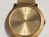 an image of a close up of a gold watch on a white surface