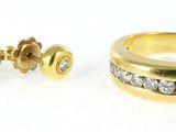 two gold rings and a pair of earrings on a white surface