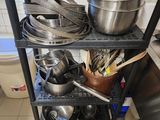 many pots and pans on the shelf in the kitchen
