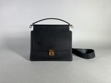 a black leather handbag with a gold clasp on a white background