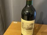 une bouteille de vin posée sur une table à côté d'un rideau