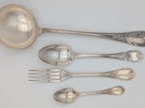 five spoons and a fork on a table