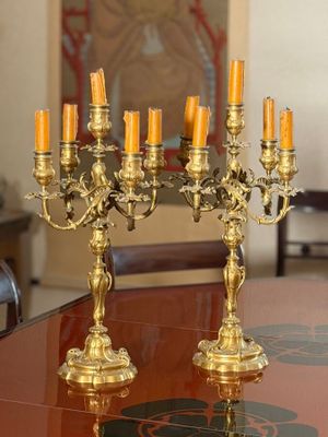 candles are lit on a table in a formal dining room