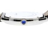 a close up of a watch with a blue stone on the face