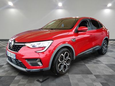 a red car is parked in a room with a checkered floor