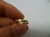 une personne tenant une bague en or dans la main