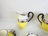 quatre tasses et un pichet posés sur une table