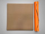 an orange yoga mat next to an orange yoga mat on a gray background