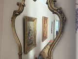 un miroir accroché au mur à côté d'un vase