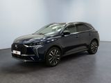 un SUV bleu foncé garé dans une pièce au sol noir