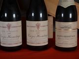 several bottles of wine are lined up on a red table