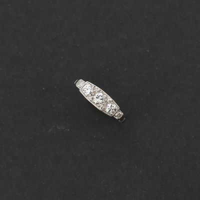 une vieille bague sertie d'un diamant taillé, posée sur une surface noire