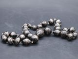 a close up of a bunch of silver beads on a table