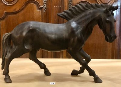 une statue représentant un cheval au galop posée au sol