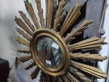 a gold sunburst sitting on top of a wooden table
