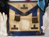 an image of a blue and gold apron and gloves on a white surface