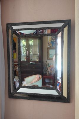 un grand miroir accroché au mur au-dessus d'une baignoire