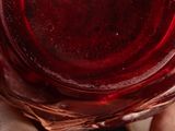 a person holding a glass of red wine in their hand