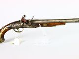 an old gun that is on display on a white surface