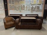 plusieurs chaises et une table dans une pièce, avec une fenêtre derrière elles