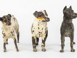 three figurines of dogs standing next to each other on a white surface