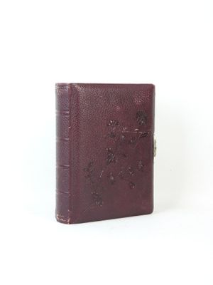 an old book is sitting on a white surface with a white background