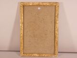 an old picture frame sitting on top of a table next to a wall