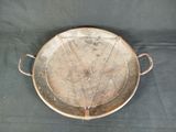 a large metal pan with handles on a table