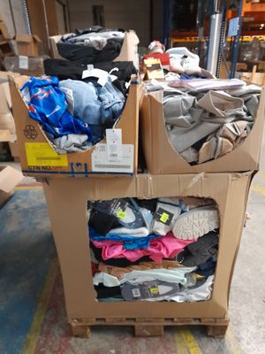 Des cartons de vêtements sont empilés les uns sur les autres dans un entrepôt
