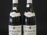 two bottles of wine sitting on top of a table next to each other