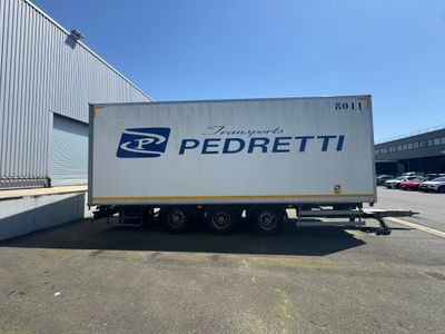 un grand camion blanc garé devant un immeuble