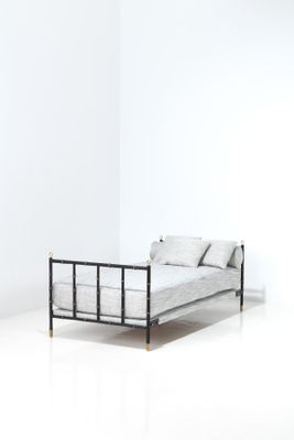 un lit avec un cadre en métal dans une chambre blanche