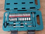 un ensemble d'outils rangé dans une mallette bleue, posé sur une table en bois