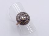 silver ring with a brown stone in it on a clear ring holder
