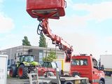 a red truck with a crane attached to it ' s back