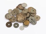 a pile of old coins on a white surface