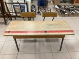 une table avec deux chaises et un plateau orné d'une bande rouge