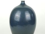 a blue vase that is sitting on a white surface