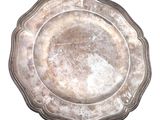 une assiette en argent posée sur une surface blanche