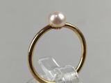 a close up of a gold ring with a pearl on top of it